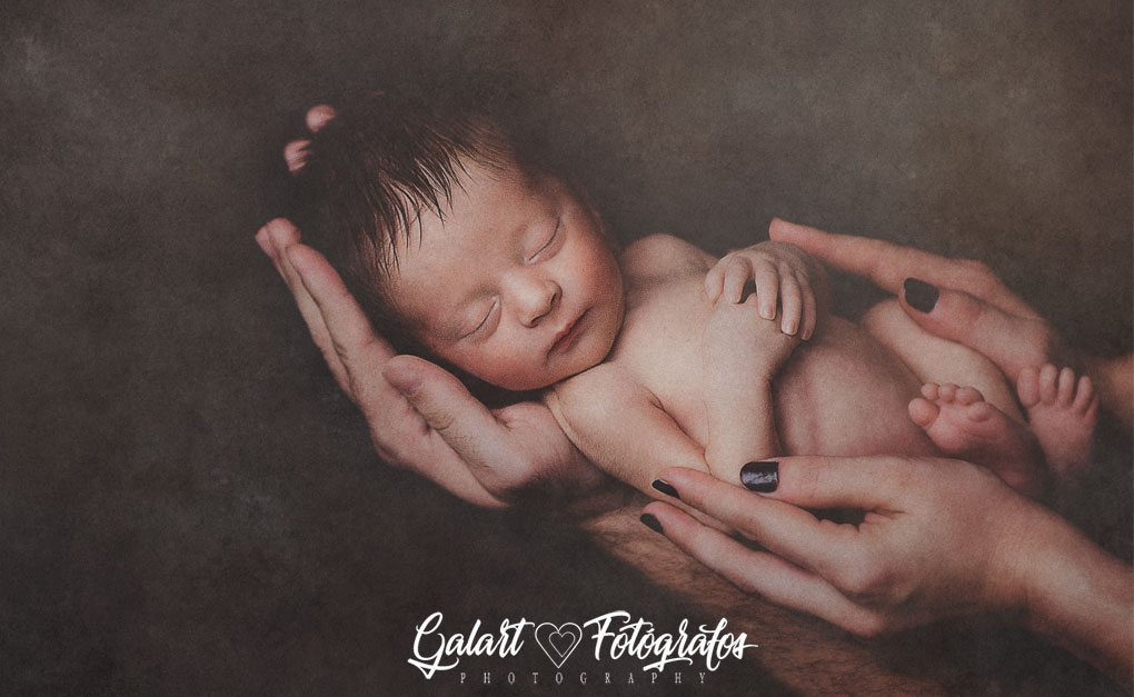 Fotos de bebé, recién nacido entre las manos de sus padres, foto de galart fotógrafos